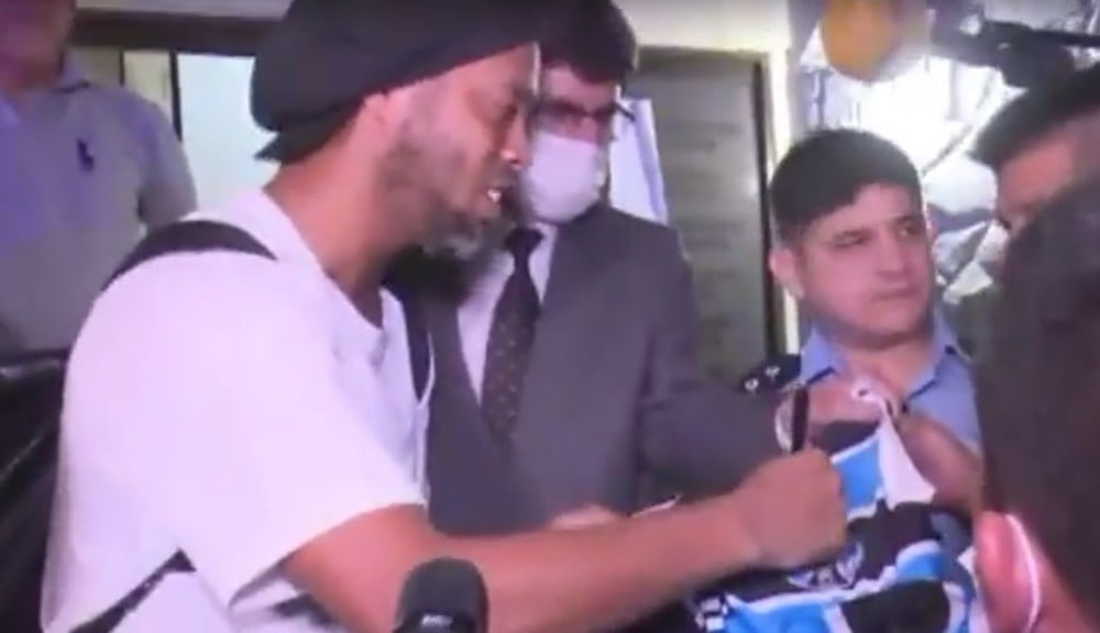 Ronaldinho paga fiança milionária e dá autógrafo em camisa do Grêmio na saída da prisão; veja Ronaldinho