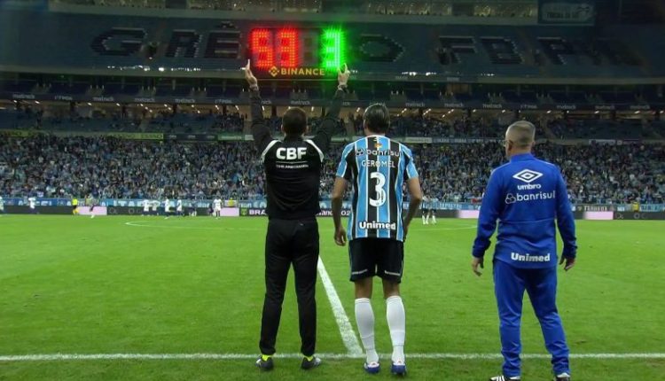 Pedro Geromel, com a camisa 3 do Grêmio, entra no jogo, contra o Fortaleza, pelo Brasileirão, ao seu lado, o 4º árbitro levanta a placa de substituição.