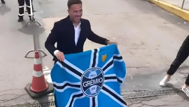 Arthur segurando bandeira do Grêmio, em sua chegada no Aeroporto Salgado Filho em Porto Alegre