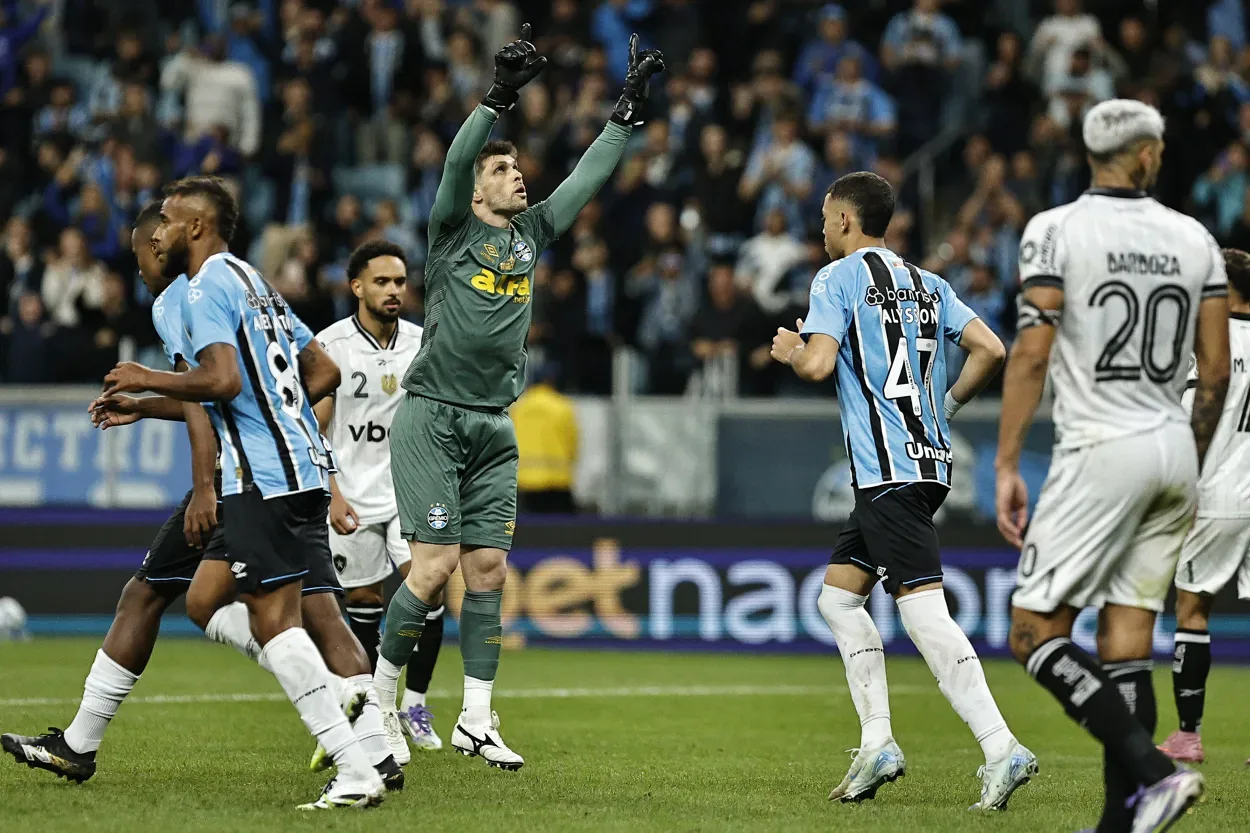 Volpi marca mais um gol pelo Grêmio e celebra "ajuda" de Kannemann na marcação do pênalti Tiago Volpi (1), goleiro do Grêmio comemora gol marcado durante partida contra o Botafogo, válida pela 16ª rodada do Campeonato Brasileiro 2025. FOTO: Roberto Vinícius/AGAFOTO/Gazeta Press